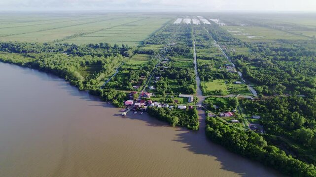 Fly over rural village by commewijne river, Johan and Margaretha plantation, sky reveal, Suriname
