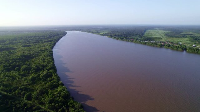 Fly over large wide commewijne river, mari&euml;nburg in the distance, Suriname