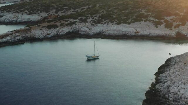Lonely Sailboat On The Rocky Coast Near Susac Island During Sunset In Croatia. Aerial Shot