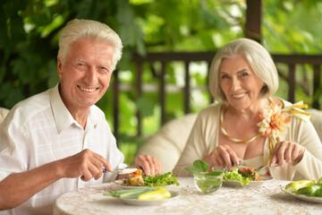 Happy senior couple having diner and posing at home