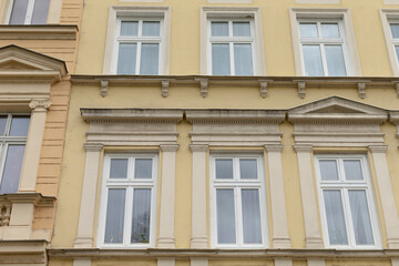 A bright yellow building that features numerous windows all over its facade, creating a vibrant and welcoming appearance