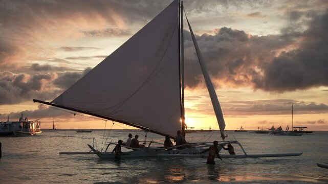 Sunset sailing with a traditional paraw boat in the turquoise waters of Boracay Island, Philippines