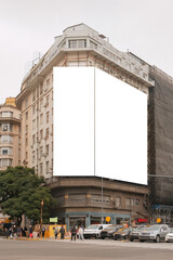 Mock up of giant blank vertical advertising billboards on facade of building located at road junction. Urban city street scene. Out of home OOH advertisement template