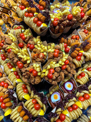 Delicious snack cone with french fries, nuggets and tomatoes at the Boqueria market, Barcelona, Spain. Food market. 