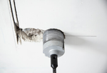 drilling holes in a concrete wall for socket boxes with a diamond core bit, industry. Copy space...