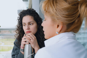 Two women, mother and daughter, are talking and reflecting together