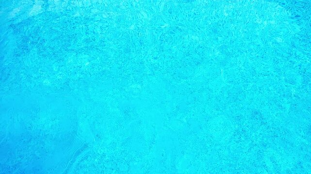 Diving board lead into refreshing blue swimming pool in summer