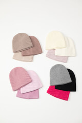 Collection of stylish knitted hats (pink, beige, black, white, gray, red) Composition of lined hats. A set of autumn - winter hat accessories