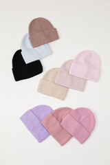 Collection of stylish knitted hats (pink, beige, black, white, gray, red) Composition of lined hats. A set of autumn - winter hat accessories