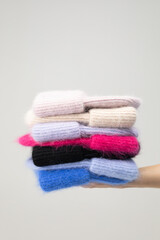 A collection of stylish knitted hats. The girl holds hats in her hand. A set of accessories of hats autumn - winter