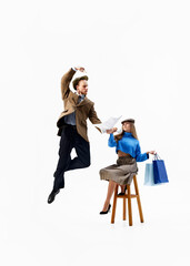 Fashionable duo, man reads newspaper, while woman holds shopping bags, merging vintage vibes with...