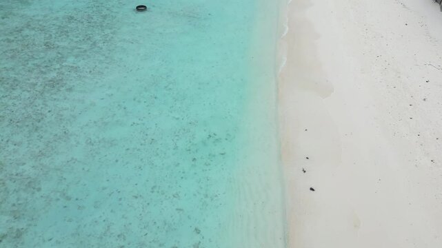 Aerial top down of white sand tropica paradise beach and blur clear turquoise Indian Ocean water in Maldives paradise island