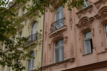 A detailed closeup shot of a large building that features numerous windows as well as multiple balconies that adorn its exterior