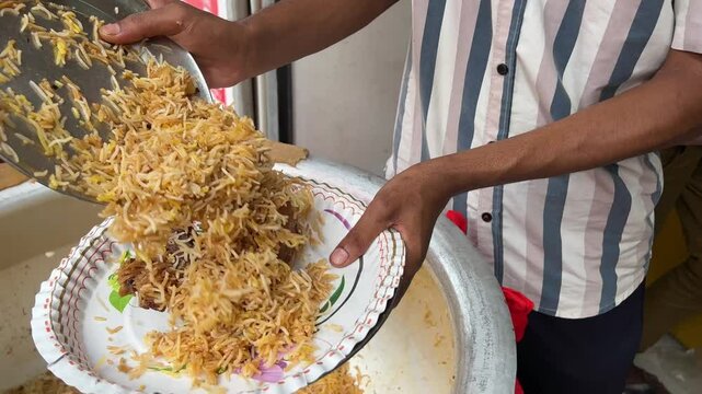 Kolkata style Mutton biryani being served in a paper plate in a shop in Kolkata.