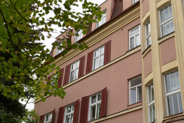 Obraz premium There is an attractive building that features numerous windows adorned with charming red shutters, enhancing its visual appeal and character