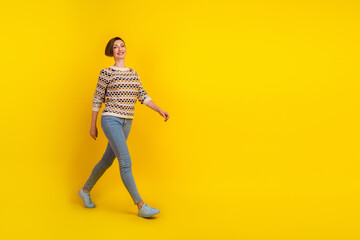 Full length portrait of beautiful woman go walk over yellow color bright copyspace background