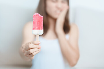 Teeth Sensitive to Cold concept. woman hold Ice cream and having toothache and pain after eat....