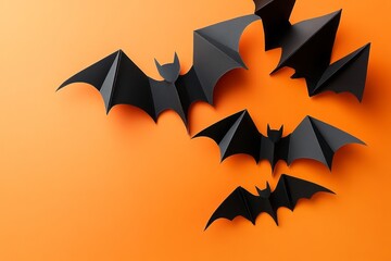 Fototapeta premium Black paper bats on an orange background, a Halloween concept. 