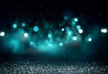 Fototapeta premium Abstract background of blurred teal and white lights on a black backdrop.