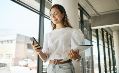 Business woman, folder and smile with phone in office for text message, checking notifications and networking. Professional, employee and happy with smartphone at workplace for communication or email