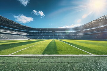 Fototapeta premium A large stadium with empty seats and green grass field under blue sky. The scene is illuminated by bright sunlight, creating a sense of excitement for the game