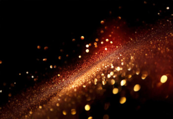 Fototapeta premium Abstract bokeh of sparkling gold glitter on a black background.