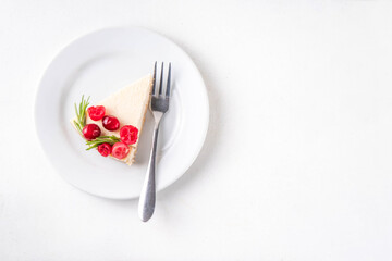 Tasty Christmas cheesecake with cranberries and rosemary decorated like Christmas wreath. Simple elegant winter white dessert 