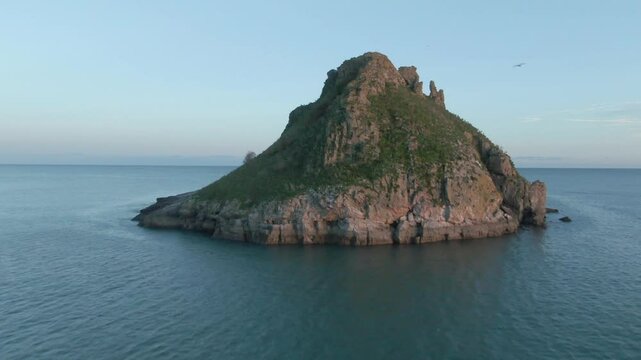 Thatcher Rock Torquay Drone Footage In the English riviera, sunny day, beautiful sky Ariel view of scenic landscape With moon in background Fly through