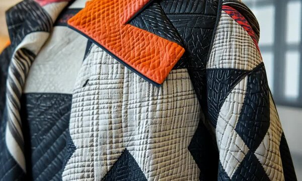 Close up of a colorful fabric with a black seam on a mannequin.