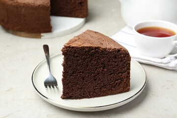 Piece of tasty chocolate sponge cake served on light table, closeup