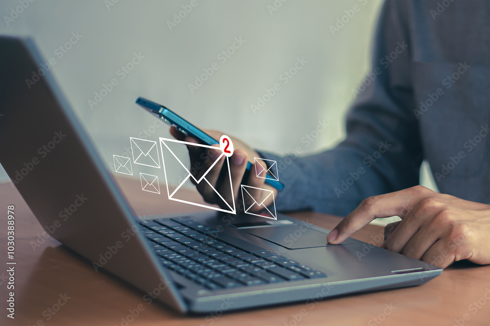 Wall mural man uses laptop with notification icon of two new email messages. communication business technology.