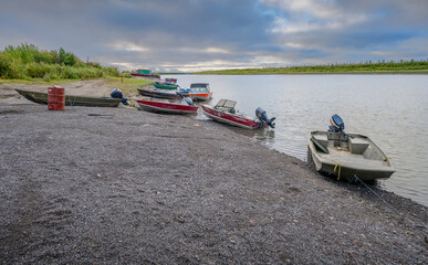 Fototapeta premium Fishing boats on the shore of the Mackenzie River at Inuvik, Northwest Territories, Canada