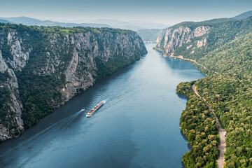 Aerial view of a cruise ship traveling through the Danube River's Iron Gate between Serbia and...