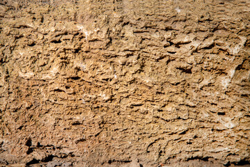The background of the wall is made of a cut of the ground on a clear sunny day, texture backgrounds for graphic design. The wallpaper is abstract.