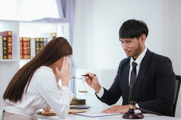 Confident businesswoman sitting at desk reviewing legal documents and contracts to ensure fairness and balanced decisions in legal and criminal matters.