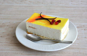 a slice of creamy cake with lemon glazing and a spoon on a plate 