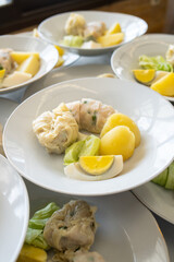 Siomay with hard boiled egg, potato and cabbage on a white plate
