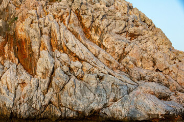 Brown colored Basalt sheer rocks  cuted by cracks due geology and by constant wind and temperature fluctuations. This cliff downs to the see and riddled with caves