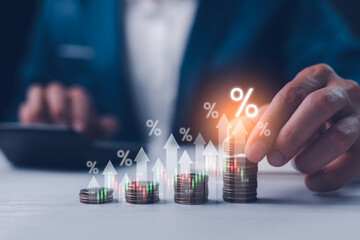 Dividend and interest rates with symbols and arrows up on stacks of coins, representing returns on...