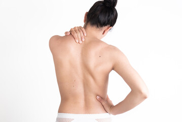 Obraz premium young woman, from behind, showing her back with scoliosis, pain, bad posture