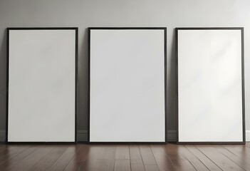 Three empty picture frames on a wooden floor against a white wall.