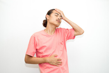 An Indonesian, Asian man wearing a pink tshirt having a headache, chest pain and stomach ache with hands holding head, chest and stomach. isolated in white background