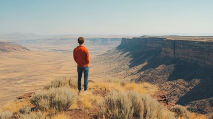 Fototapeta premium Man Standing on Cliff Overlooking Canyon Landscape