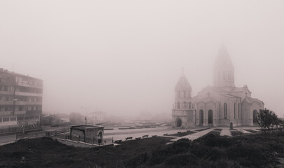 Fototapeta premium Fog envelops the historic architecture of Nagorno Karabakh during a quiet morning, lending an air of mystery to the landscape