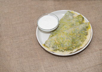 national cuisine, kutab with greens on a plate with kefir sauce