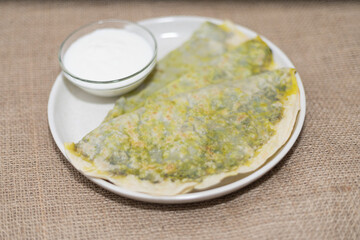 national cuisine, kutab with greens on a plate with kefir sauce