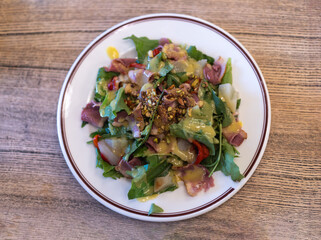 salad of fresh vegetables, greens and beef with sauce