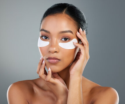 Woman, skincare and eye patch in studio portrait with process, test and wellness by background. Girl, model and person with cosmetics, dermatology and pads with facial transformation in Brazil
