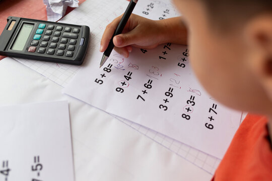 Over the shoulder view of a child who has dyslexia and dyscalculia doing math homework.