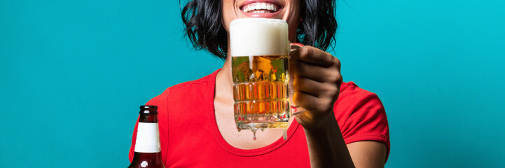 Young woman pouring craft beer in glass with foam – isolated girl holding in hand fresh and cold foamy amber beer mug - horizontal web banner size for header